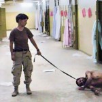 Abu Ghraib: Le soldat américain Lynndie England tient en laisse un prisonnier couhé sur le sol. (Photo: domaine public)