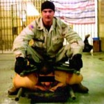 Abu Ghraib: 9:19 p.m., 28 novembre 2003. Le sergent de l'armée américaine, Ivan Frederick, assis sur un prisonnier irakien. Cette photo a été utilisée comme preuve des mauvais traitements envers les détenus. (Photo: domaine public)