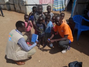 Deux officiers de protection nationale, Peter et Wani, avec des enfants sur le site de protection civile de Djouba, Soudan du Sud. (Photo: nonviolentpeaceforce.org)